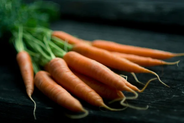 A bunch of carrots on a table top.