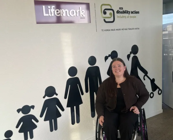 Gabby in front of the sign in the Lifemark office.